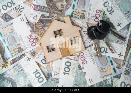 Prêt hypothécaire ou concept de prêt. Maison modèle en bois et clés sur l'argent polonais zloty, PLN zloty billets. Acheter une maison, un appartement ou un appartement en Pologne. Banque D'Images