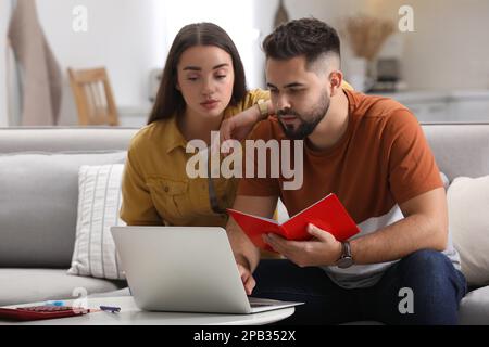 Jeune couple discutant du budget familial à la maison Banque D'Images