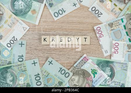 Mot kredyt en polonais, signifie prêt ou hypothèque. Acheter une maison ou un appartement en Pologne. Composition de la pose à plat avec des billets de banque zloty PLN. Banque D'Images
