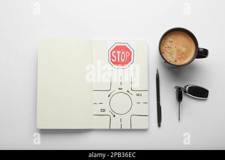 Composition avec cahier d'exercices pour les leçons de conduite sur fond blanc, vue de dessus. Réussite de l'examen de licence Banque D'Images