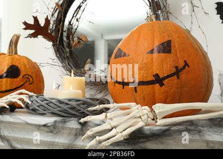 Citrouilles aux visages effrayants dessinés et bougies allumées sur la table. Décoration pour Halloween Banque D'Images