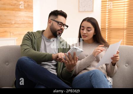 Jeune couple discutant du budget familial à la maison Banque D'Images