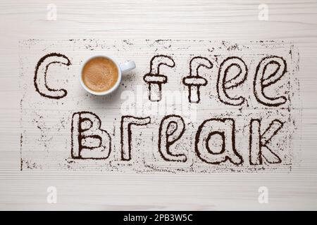 Phrase Pause café faite avec une tasse de boisson et de poudre sur une table en bois clair, plat Banque D'Images