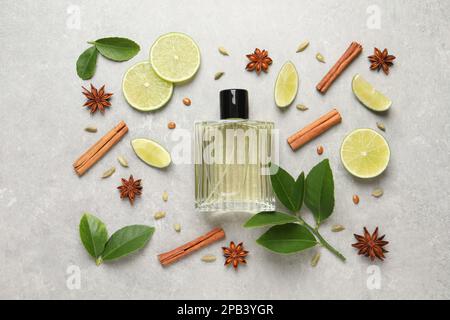 Composition de la couche plate avec bouteille de parfum, citron vert et épices sur fond gris clair Banque D'Images