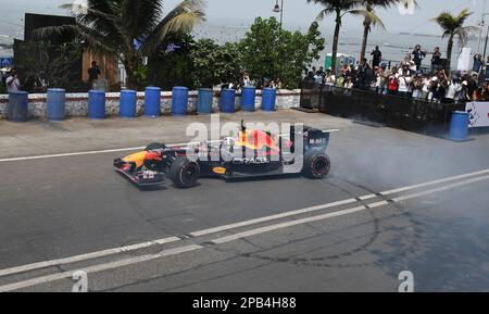 Le public regarde l'ancien pilote de Formule 1 David Coulthard conduire la voiture de course Red Bull RB7 dans les rues de Mumbai. Banque D'Images