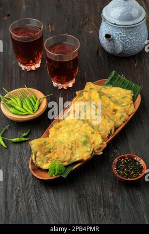 Tempe Mendoan, revêtement de tempeh avec farine jaune et oignon de printemps et friture profonde. Mangez avec le thé. Cuisine traditionnelle indonésienne Banque D'Images