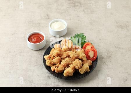 Maïs soufflé au poulet, petites tranches de poulet avec revêtement de farine croustillante et friture profonde. Servi avec de la manonaise et de la sauce Chili épicée. Copier l'espace pour le texte Banque D'Images