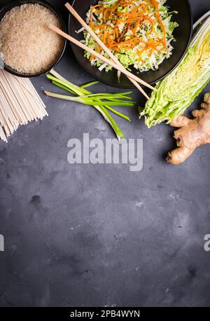 Ingrédients pour faire le dîner chinois : nouilles de blé, riz, chou napa, gingembre, oignon vert. Ingrédients de cuisine asiatique. Vue de dessus. Préparation en bonne santé Banque D'Images