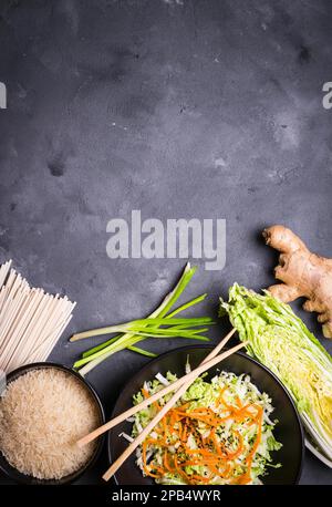 Ingrédients pour faire le dîner chinois : nouilles de blé, riz, chou napa, gingembre, oignon vert. Ingrédients de cuisine asiatique. Vue de dessus. Préparation en bonne santé Banque D'Images