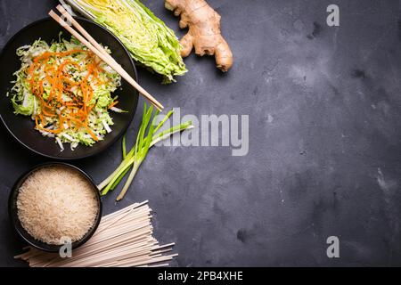 Ingrédients pour faire le dîner chinois : nouilles de blé, riz, chou napa, gingembre, oignon vert. Ingrédients de cuisine asiatique. Vue de dessus. Préparation en bonne santé Banque D'Images