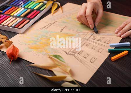 Femme dessin beau bâtiment avec pastel doux à table en bois, gros plan Banque D'Images