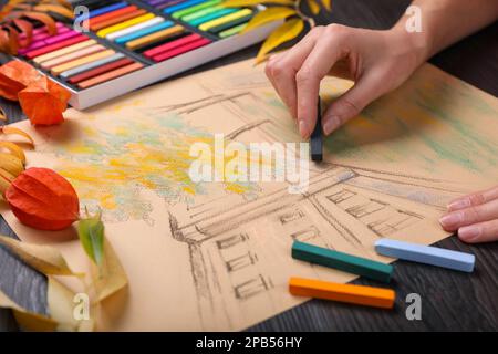 Femme dessin beau bâtiment avec pastel doux à table en bois, gros plan Banque D'Images