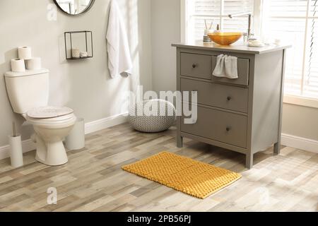 Tapis près de la base de l'armoire avec lavabo dans la salle de bains Banque D'Images