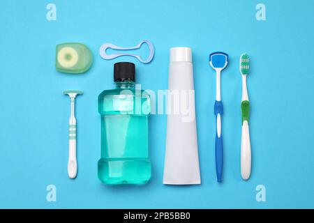 Composition de la couche plate avec nettoyants pour langue et produits d'entretien des dents sur fond bleu clair Banque D'Images