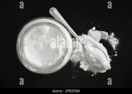 Vue de dessus du bicarbonate de soude sur fond noir Banque D'Images