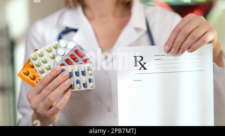 La pharmacienne tient le papier d'ordonnance et beaucoup de pilules médicales dans ses mains de près. Banque D'Images