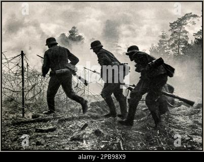 ARDENNES WW2 soldats nazis sous le feu. Avance allemande sur le champ de bataille : les troupes allemandes de la Wehrmacht nazie sous le feu français allié avancent à travers un front de champ de bataille de barbelés. Ardennes France. Années 1940 seconde Guerre mondiale seconde Guerre mondiale Banque D'Images