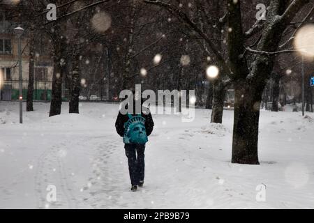 Moscou, Russie. 12th mars 2023. Les gens marchent à travers un parc de soirée dans un quartier résidentiel de Moscou pendant une forte chute de neige, Russie Banque D'Images