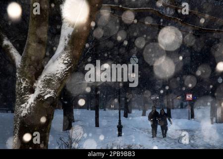 Moscou, Russie. 12th mars 2023. Les gens marchent à travers un parc de soirée dans un quartier résidentiel de Moscou pendant une forte chute de neige, Russie Banque D'Images