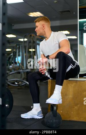 un homme blond fait de l'exercice dans la salle de gym Banque D'Images