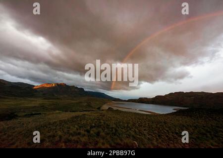 Arc-en-ciel avec nuages de tempête et lever de soleil frappant la falaise, Valle Chacabuco, Patagonie Banque D'Images