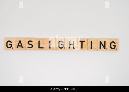 L'orthographe du titre en bois le mot gastlighting isolé sur un fond blanc Banque D'Images