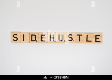 Le titre en bois épellation les mots côté Hustle isolé sur un fond blanc côté Hustle isolé sur un fond blanc Banque D'Images