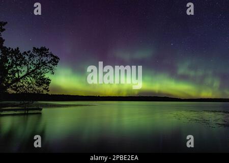 Les aurores boréales éclatent dans un ciel lumineux d'aurores au-dessus du lac du Nord du Minnesota Banque D'Images