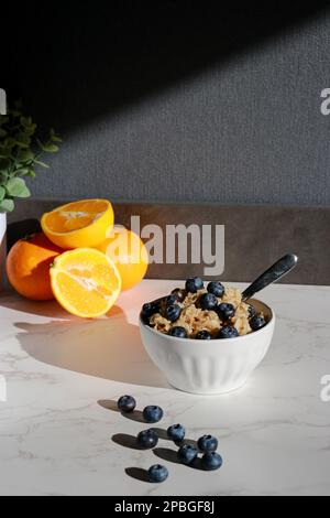 flocons d'avoine végétaliens sains avec bleuets dans un bol en porcelaine blanche Banque D'Images