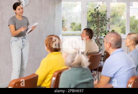 Jeune enseignante expliquant sujet à des étudiants matures Banque D'Images