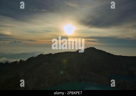 Lever de soleil atmosphérique avec ciel nuageux au-dessus du volcan du Mont Kelimutu. Banque D'Images