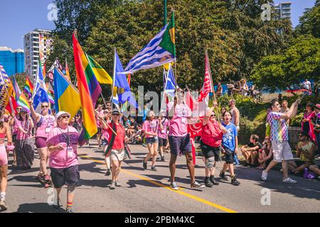 Vancouver, Canada - 31 juillet,2022: Les gens marchent sur la rue Pacific avec un drapeau arc-en-ciel pendant la parade de la fierté Banque D'Images