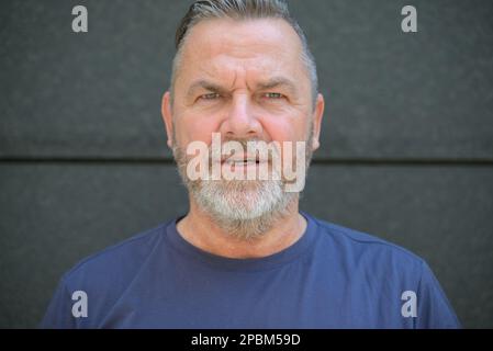 Barbu homme d'âge moyen regardant la caméra en consternation froissant son front dans le bémilderment Banque D'Images