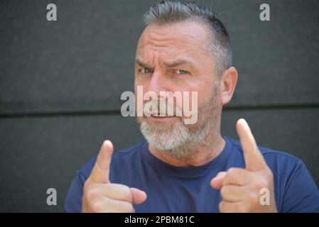 Homme argumentatif faisant un point en se mettant les doigts à la caméra comme il parle en gros plan Banque D'Images