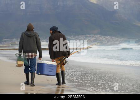 Nous avons passé un super voyage de pêche. Prise de vue en longueur de deux hommes qui pêchent tôt le matin. Banque D'Images