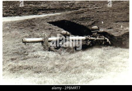 Photo noir et blanc de la deuxième Guerre mondiale les soldats allemands se préparent à tirer un lanceur de missiles anti-chars allemand Panzerschreck depuis une tranchée dans un terrain d'entraînement militaire en Allemagne 1944 Banque D'Images