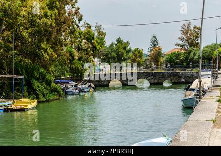 Pont sur une rivière menant à la méditerranée, Alykes, Zakynthos Grèce avec des bateaux attachés au quai Banque D'Images