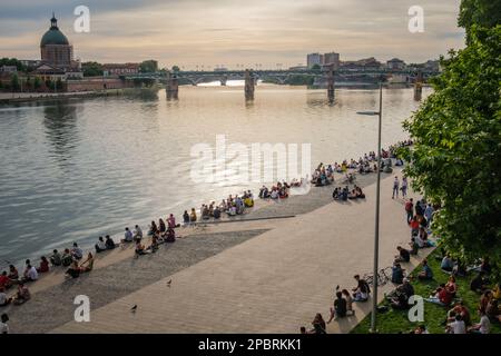 Foule de personnes se rassemblant sur le Quai de la Daurade au bord de la Garonne à Toulouse, après le confinement d'une belle soirée de printemps en 2021 Banque D'Images