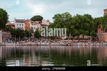 Foule de personnes se rassemblant sur le Quai de la Daurade au bord de la Garonne à Toulouse, après le confinement d'une belle soirée de printemps en 2021 Banque D'Images