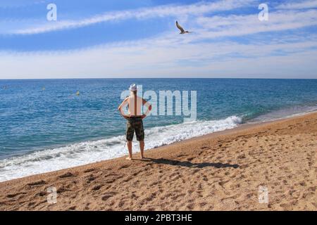 Un homme regarde la plage de Santa Susanna, Catalogne - Espagne Banque D'Images