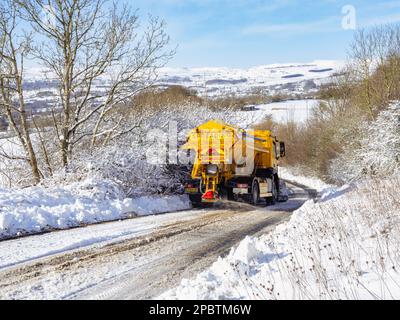 Les camions à grains répandent les grains sur une route enneigée Banque D'Images