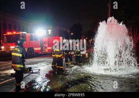 Alameda, États-Unis. 12th mars 2023. Les pompiers discutent de la solution pour arrêter l'eau. Une borne d'incendie située sur le bord de la route de Central Ave à Alameda, en Californie, a été écrasée par une voiture sur 12 mars. L'eau sous le poteau incendie est sortie et a inondé la route. Les pompiers d'Alameda ont répondu pour résoudre ce problème et ont empêché l'eau de sortir. Crédit : SOPA Images Limited/Alamy Live News Banque D'Images