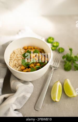 Curry de pois chiches avec des tranches de riz, de coriandre, de lime et de jalapeño Banque D'Images