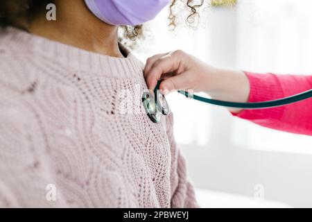 Stéthoscope placé directement sur le rythme cardiaque de l'enfant biracial pour écouter Banque D'Images