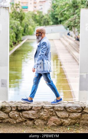 barbu, hipster mâle marchant dans un parc de la ville. Banque D'Images