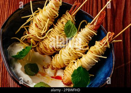 crevettes frites dans de la pâte à frire avec de la sauce et des légumes Banque D'Images