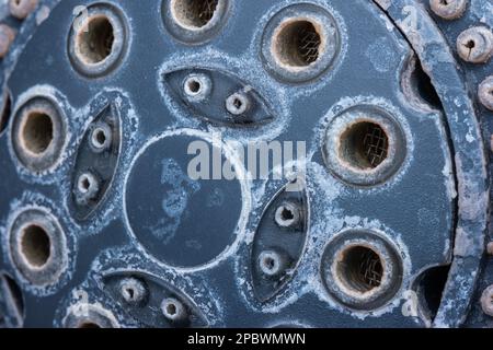 Pomme de douche en métal argenté avec dégâts d'eau durs ou dépôts calcaires. Gros plan studio macro, isolé sur fond bleu. Banque D'Images