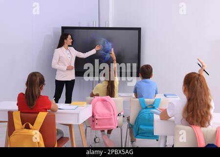 Enseignant utilisant le tableau interactif en classe pendant la leçon Banque D'Images