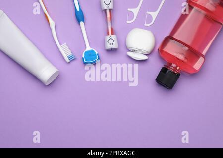 Composition de pose plate avec nettoyant pour langue et produits de soin des dents sur fond violet, espace pour le texte Banque D'Images