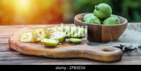 une alimentation saine. Les noix, coupées en tranches, sont dispersées sur une planche à découper. Ancienne table vintage et fruits de noyer entiers non mûrs Banque D'Images